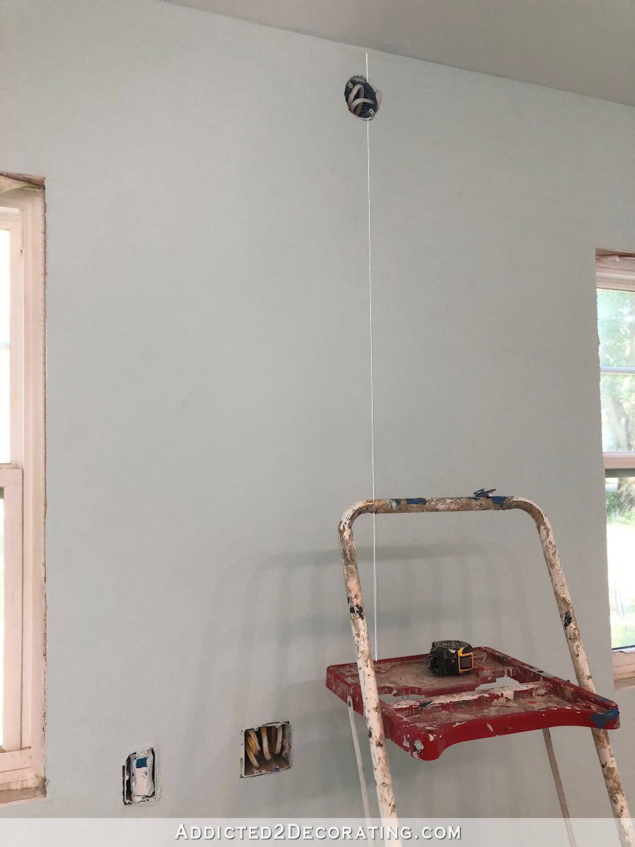 Marquez un fil à plomb au milieu du mur pour installer le papier peint.