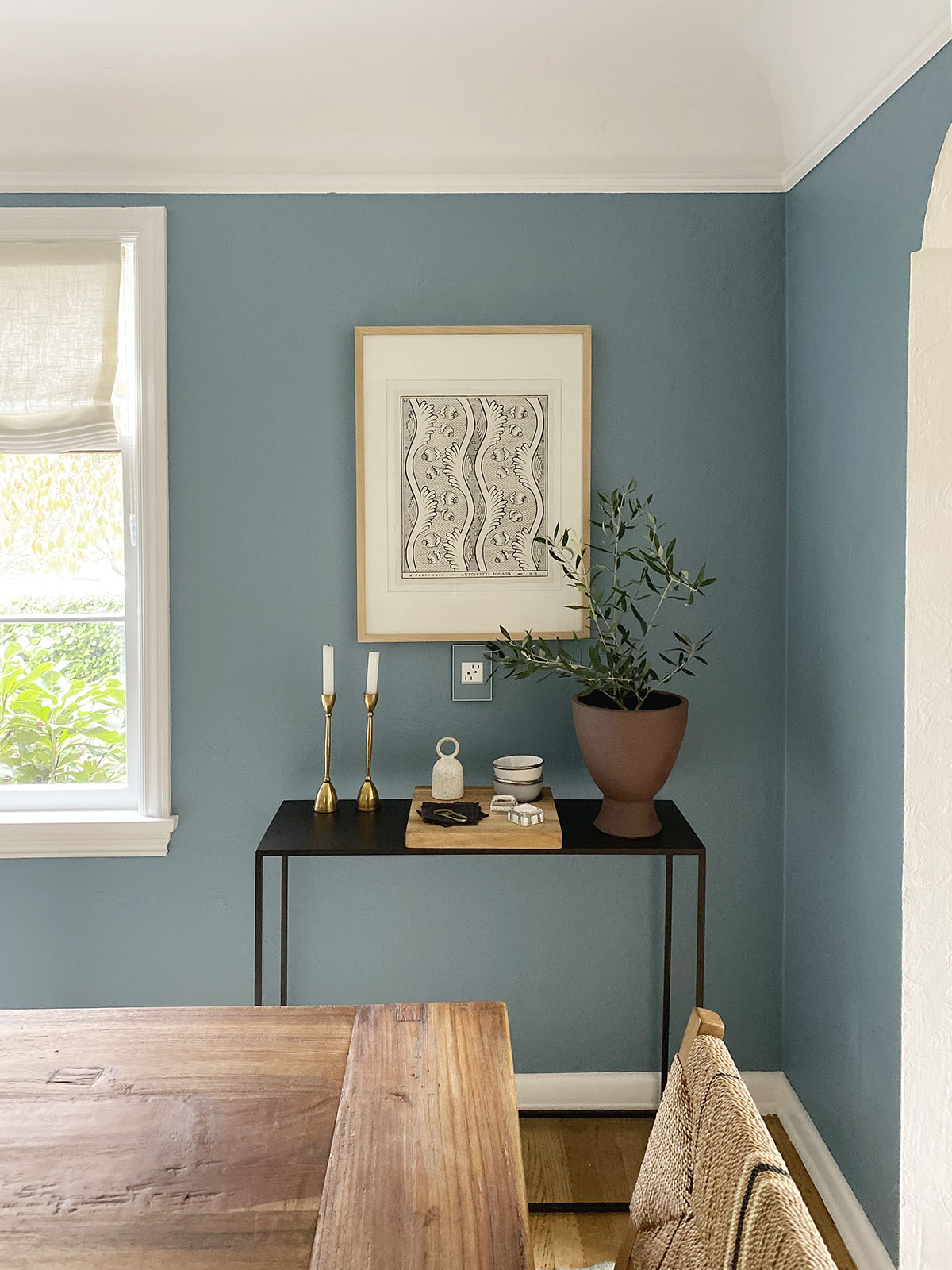 small vignette in dining room with art and console