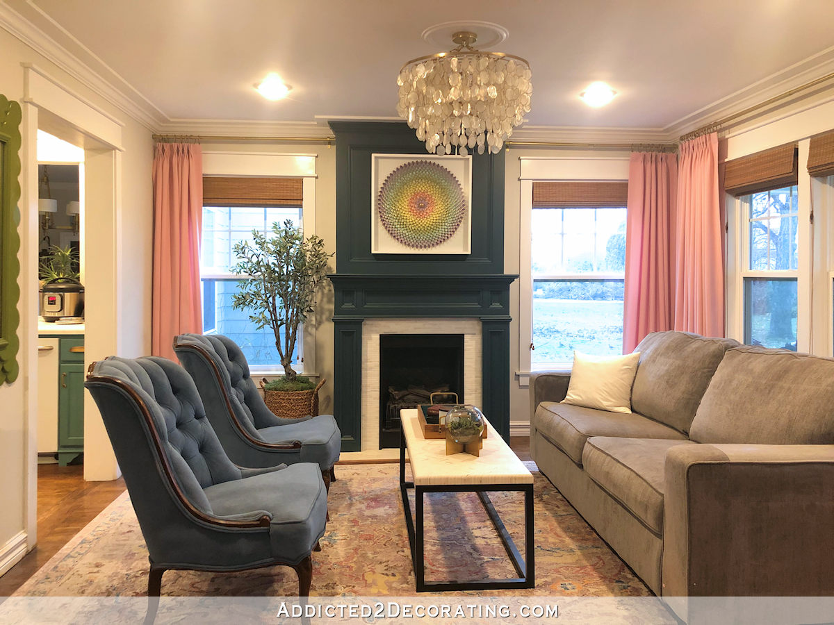 salon actuel avec cheminée turquoise, rideaux roses, canapé gris, tapis gris et lavande
